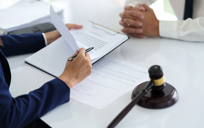 Attorney filling out a government administrative claim form in an office setting